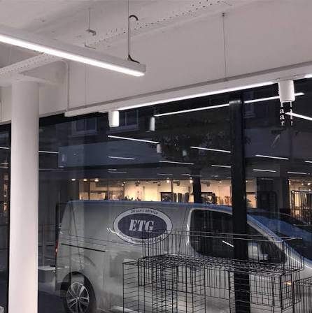De bedrijfsbus van ETG met het logo, voor een pand met nieuw aangebrachte lichtlijnen